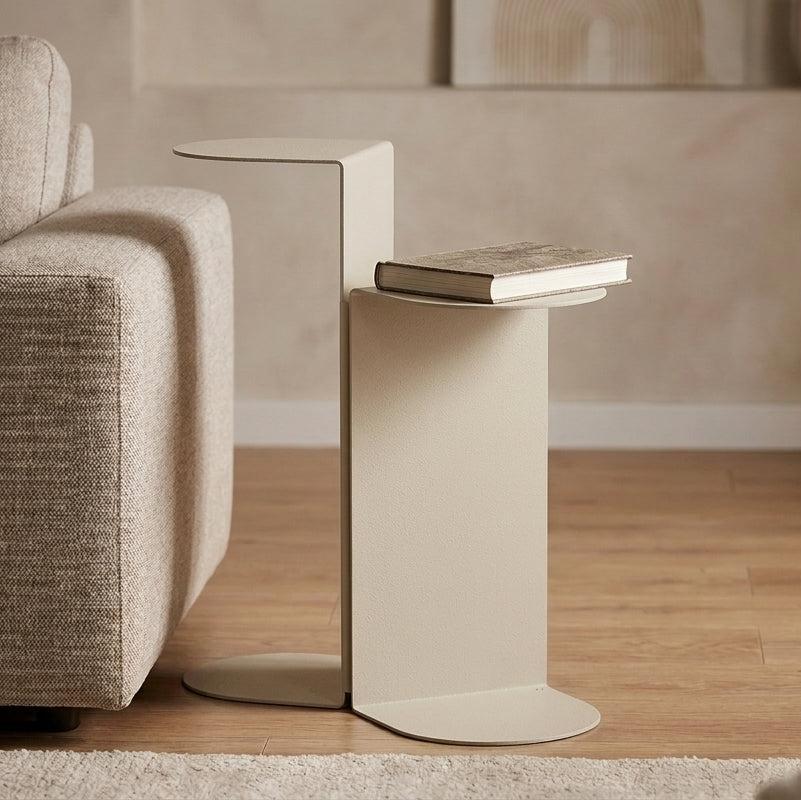 Tavolino laterale in metallo dal design minimalista accanto a un divano nel soggiorno